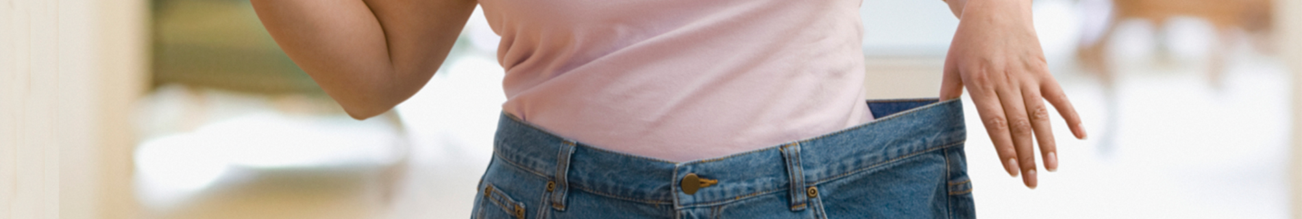 Woman with pants much bigger than her size showing weight loss.